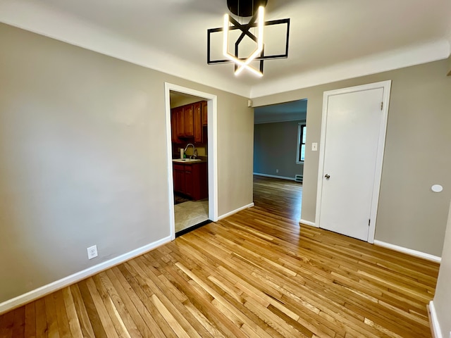 unfurnished dining area featuring sink and light hardwood / wood-style floors