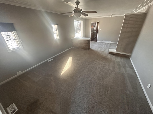 empty room featuring crown molding, ceiling fan, and dark colored carpet