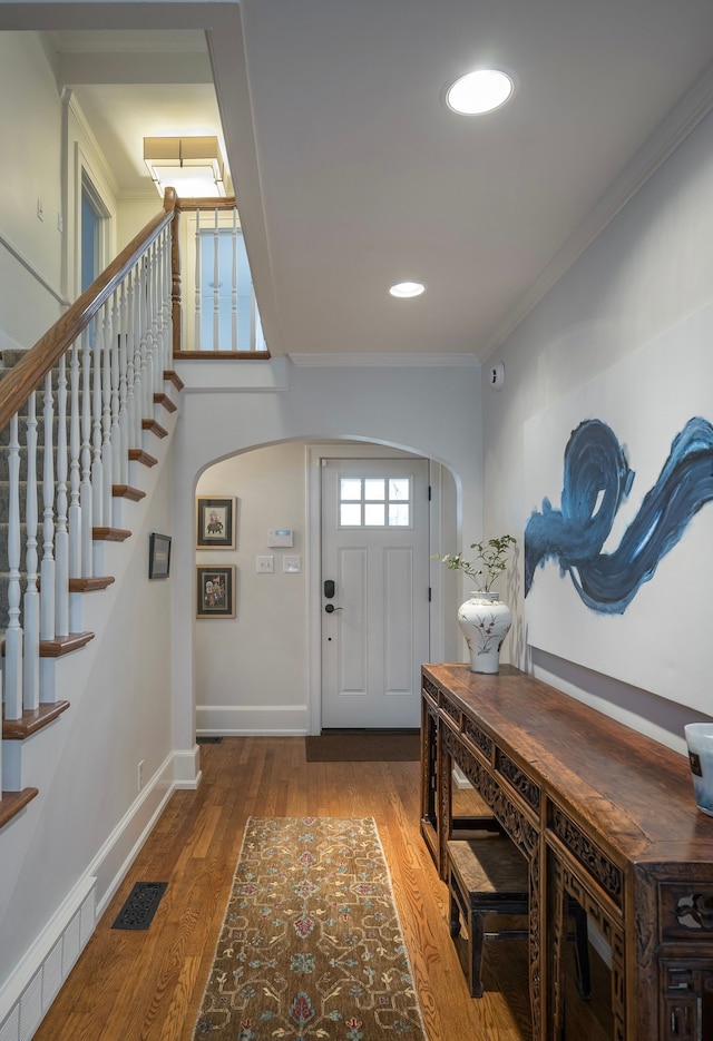 entrance foyer featuring ornamental molding and hardwood / wood-style floors