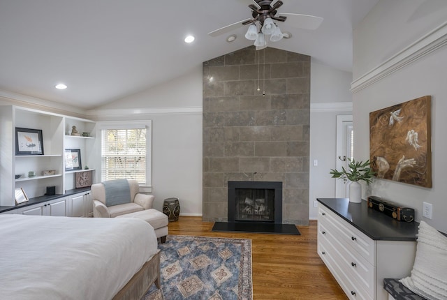 bedroom with lofted ceiling, dark wood-type flooring, and a large fireplace