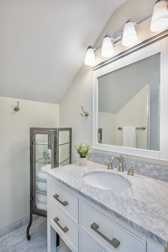 bathroom featuring vanity and lofted ceiling