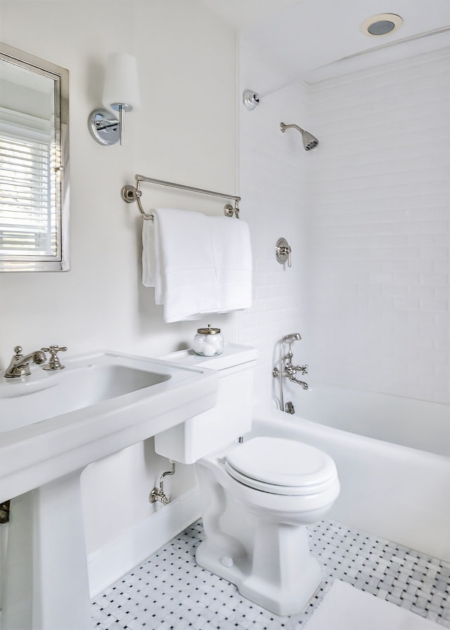 bathroom with tile patterned flooring, tiled shower / bath, and toilet