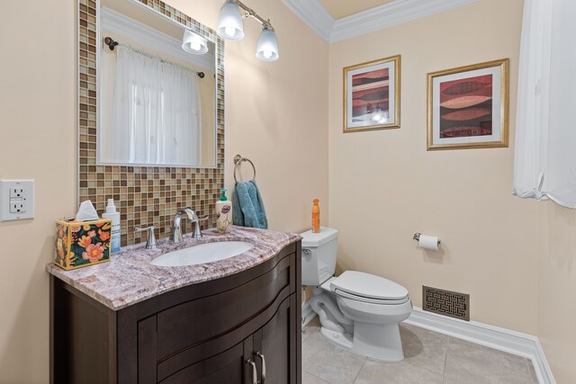 bathroom featuring toilet, crown molding, vanity, tile patterned flooring, and decorative backsplash