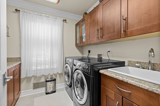 washroom with sink, cabinets, ornamental molding, light tile patterned floors, and washing machine and clothes dryer