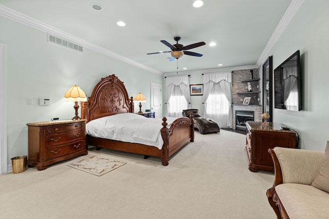 bedroom with ornamental molding, light colored carpet, ceiling fan, and a fireplace