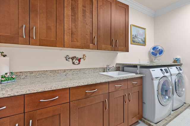 laundry area featuring sink, cabinets, ornamental molding, and washer and dryer