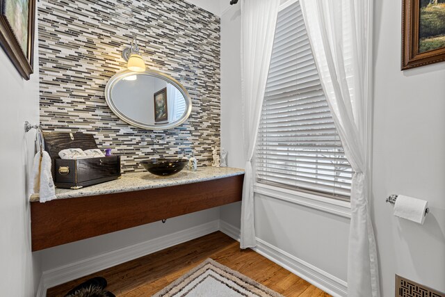 bathroom featuring tasteful backsplash, sink, and wood-type flooring