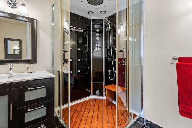 bathroom featuring vanity, hardwood / wood-style floors, and an enclosed shower