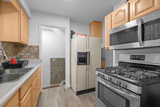 kitchen with sink, light wood-type flooring, light brown cabinets, stainless steel appliances, and decorative backsplash