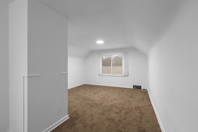 bonus room featuring lofted ceiling and dark carpet