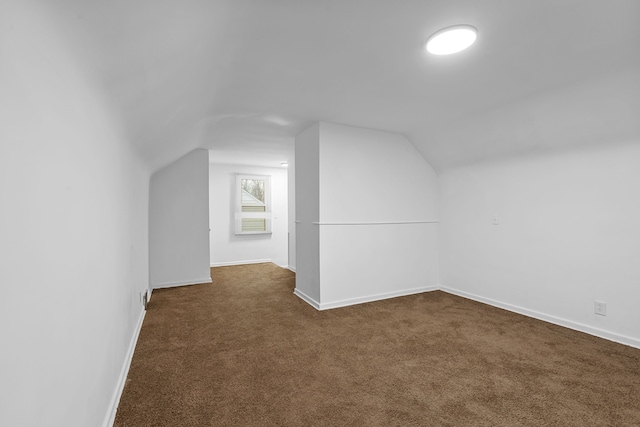 bonus room featuring lofted ceiling and dark carpet