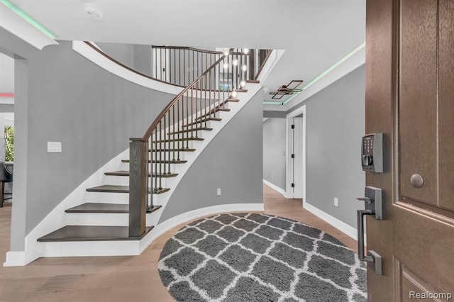 entrance foyer with a towering ceiling and wood-type flooring