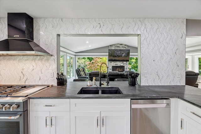 kitchen featuring white cabinetry, sink, stainless steel appliances, and wall chimney exhaust hood