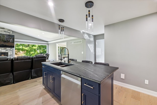 kitchen with pendant lighting, sink, stainless steel dishwasher, blue cabinetry, and a center island with sink