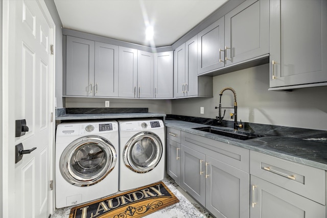 laundry room featuring cabinets, separate washer and dryer, and sink