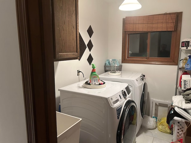 clothes washing area with sink, washer and clothes dryer, and cabinets