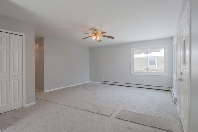 spare room featuring ceiling fan, light carpet, and baseboard heating