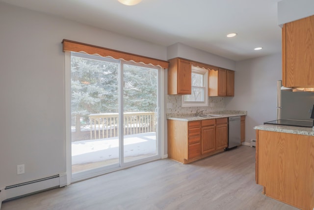 kitchen featuring sink, baseboard heating, backsplash, stainless steel appliances, and light hardwood / wood-style floors