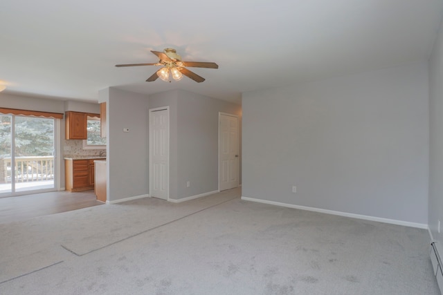 empty room with ceiling fan, light carpet, and baseboard heating