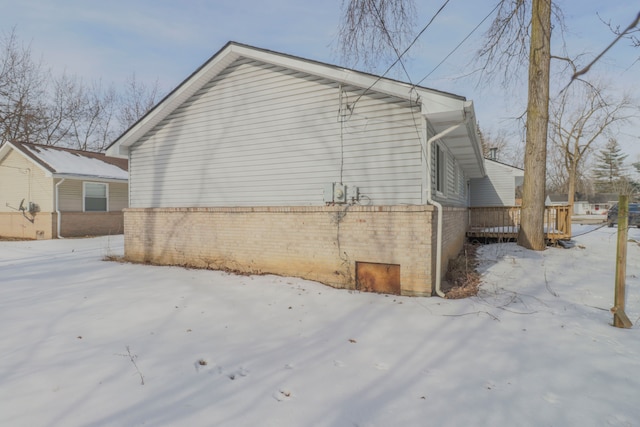 view of snowy exterior featuring a wooden deck