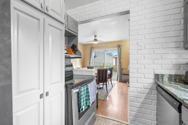 kitchen featuring white cabinets, light hardwood / wood-style floors, ceiling fan, and appliances with stainless steel finishes