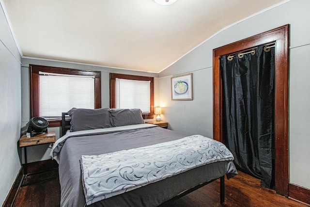 bedroom featuring dark wood-type flooring and vaulted ceiling