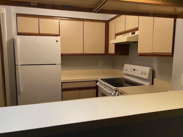 kitchen featuring cream cabinets and white appliances