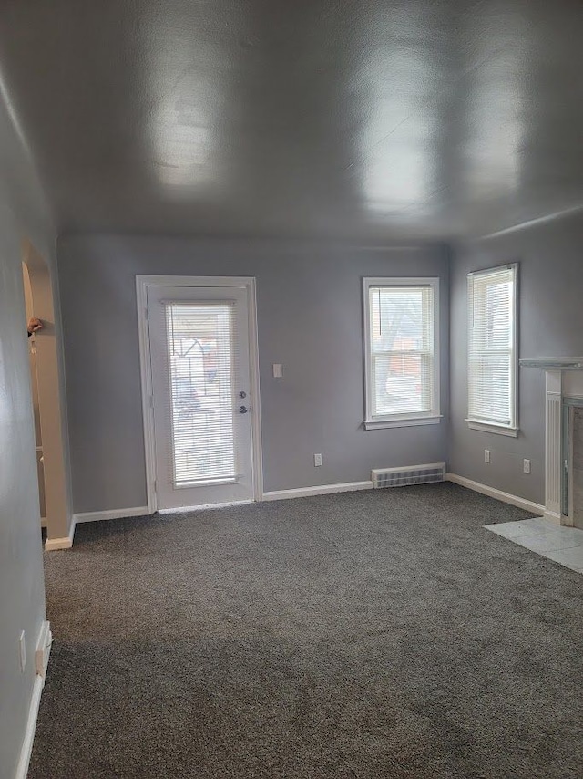 unfurnished living room featuring dark carpet