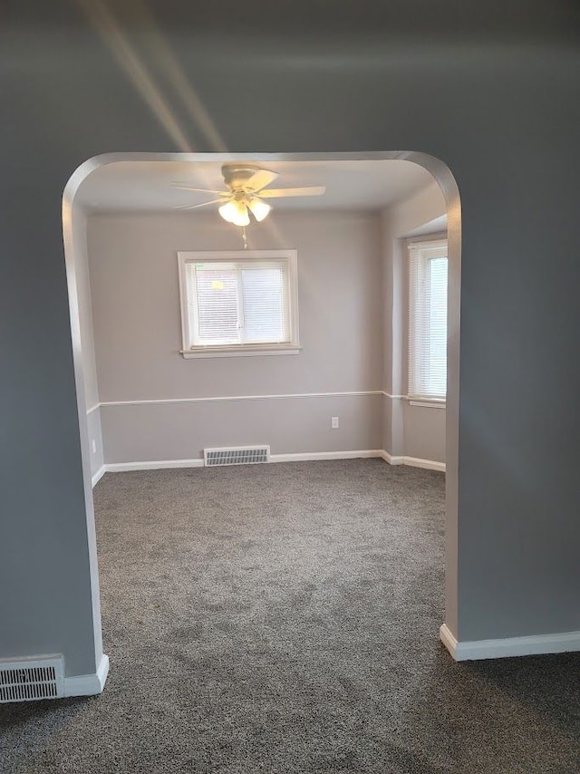 spare room with ceiling fan and carpet