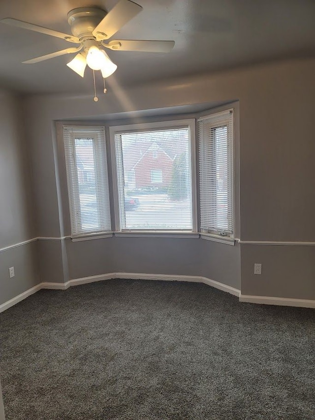 spare room featuring ceiling fan and carpet