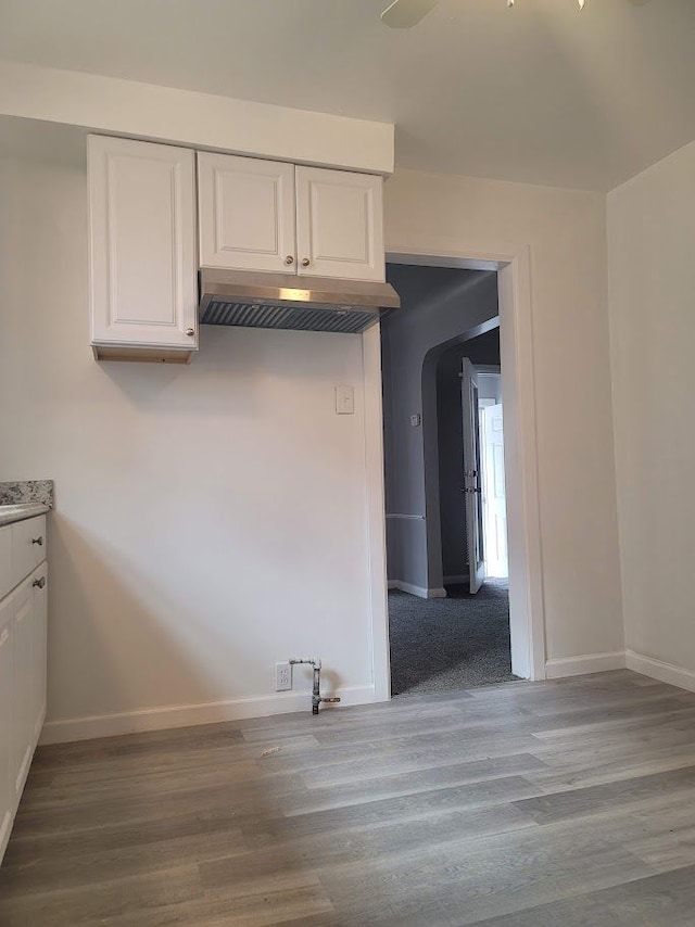 kitchen with wood-type flooring and white cabinets