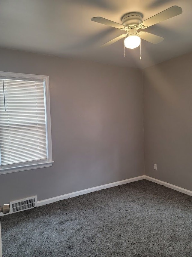 unfurnished room with ceiling fan and carpet