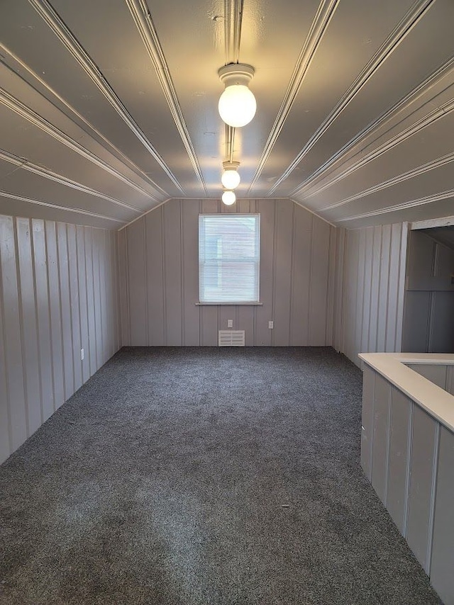 carpeted empty room with lofted ceiling