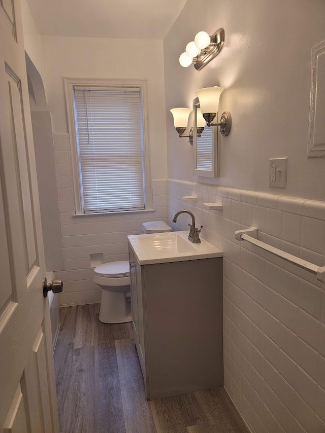 bathroom with vanity, hardwood / wood-style floors, toilet, and tile walls