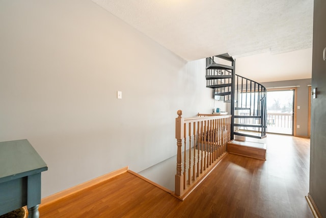 staircase with baseboards and wood finished floors