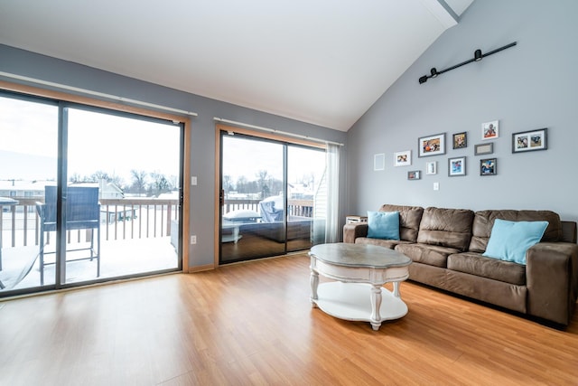 living area with wood finished floors and high vaulted ceiling