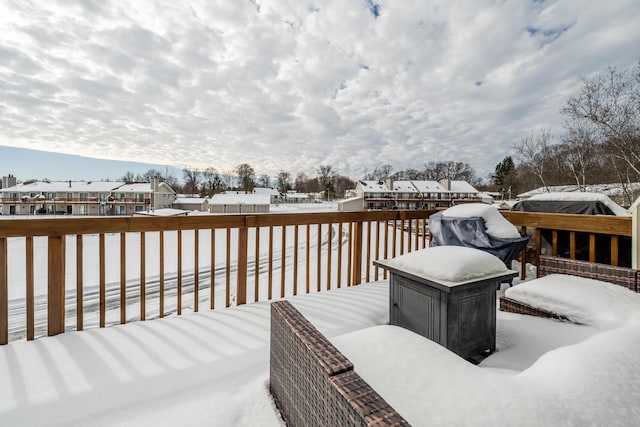 snow covered deck featuring a residential view