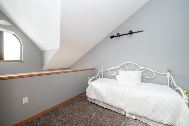 carpeted bedroom featuring baseboards and vaulted ceiling