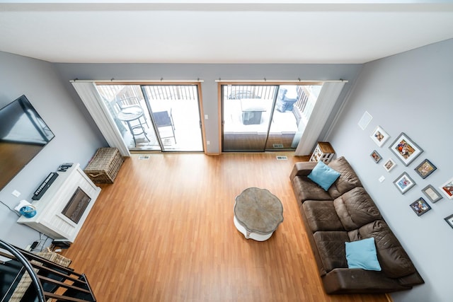 living area with visible vents and wood finished floors