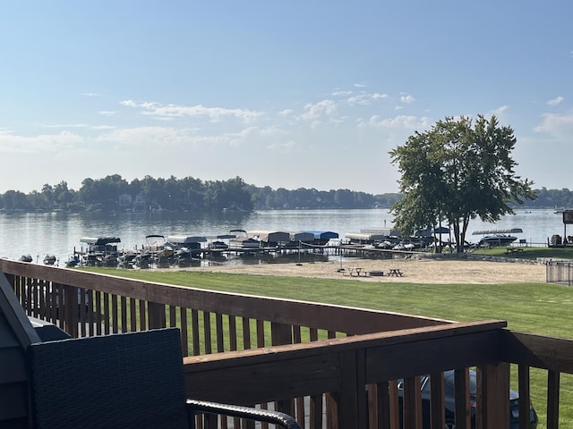 wooden terrace featuring a lawn and a water view