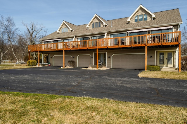 view of property with an attached garage, french doors, driveway, and a shingled roof