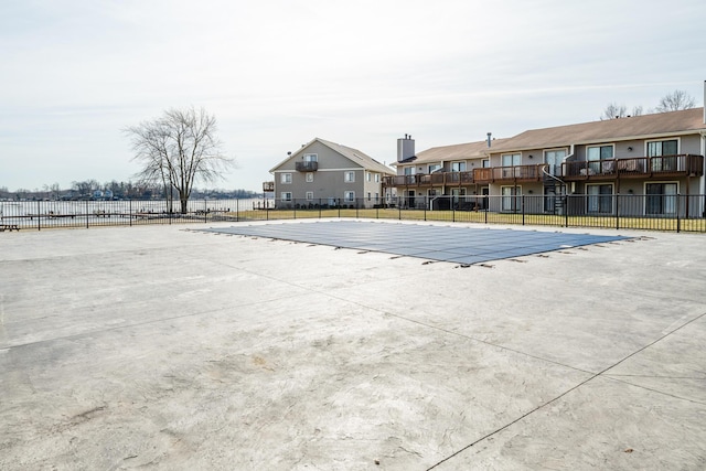 community pool featuring a patio, fence, and a residential view