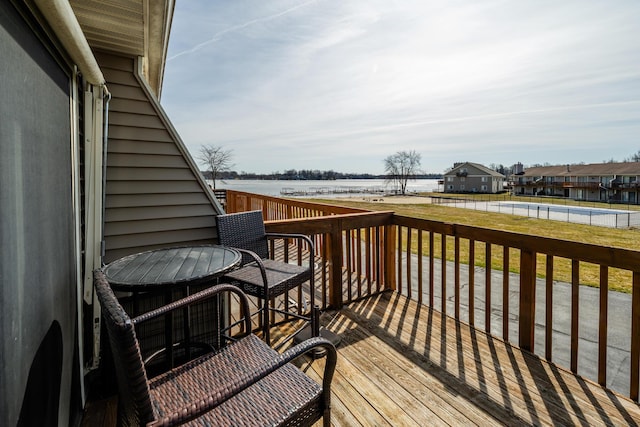 deck with a yard and a water view