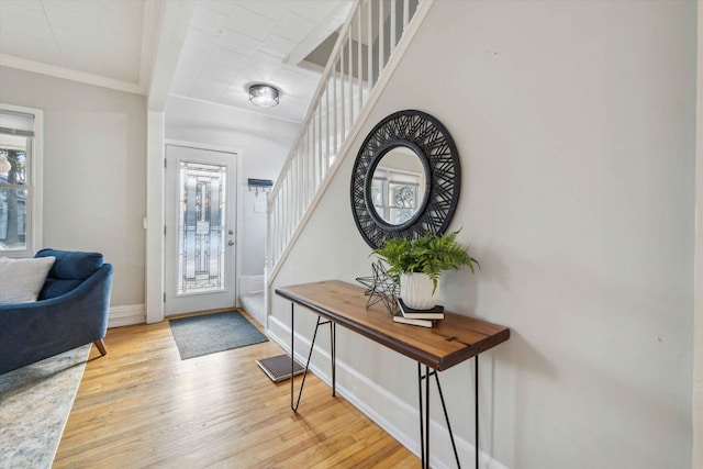 entryway featuring ornamental molding and light hardwood / wood-style floors