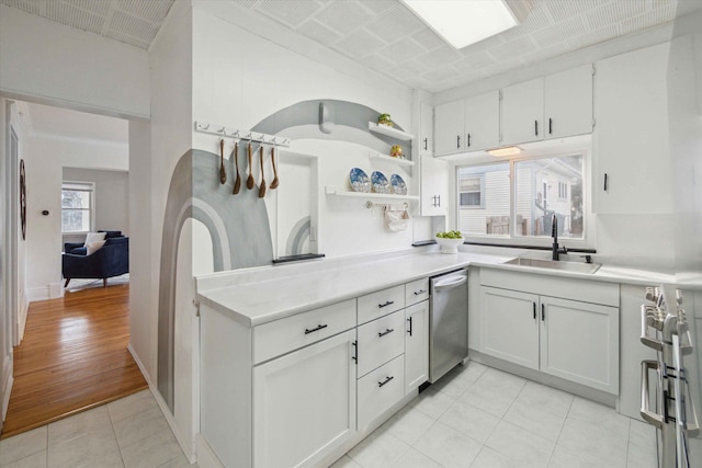 kitchen with light tile patterned floors, appliances with stainless steel finishes, sink, and white cabinets