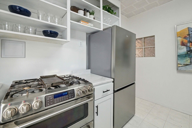 kitchen with stainless steel appliances, white cabinetry, and light tile patterned floors