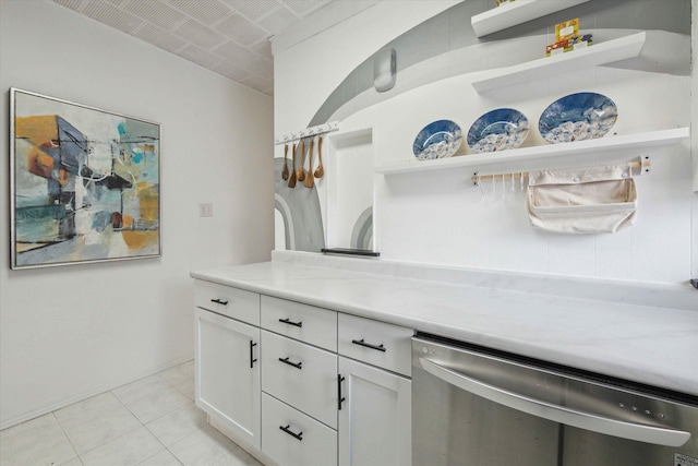 kitchen with white cabinetry, stainless steel dishwasher, and light tile patterned floors