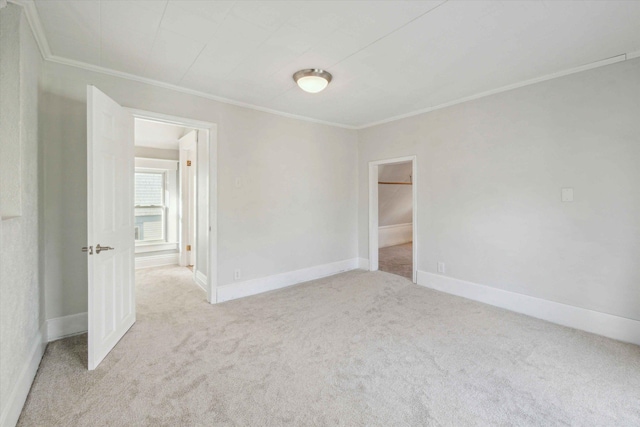 unfurnished room featuring light colored carpet and ornamental molding