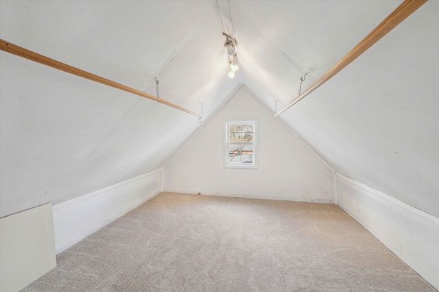 bonus room featuring vaulted ceiling and light colored carpet