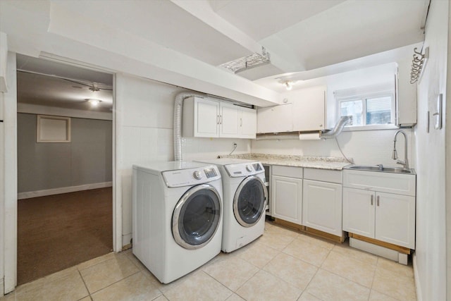 laundry area with independent washer and dryer, cabinets, sink, and light tile patterned floors